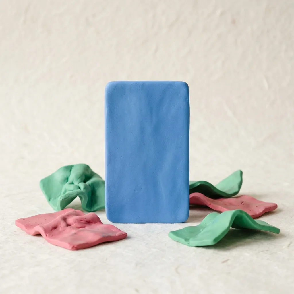 A clay scene of one polished on-brand ad card standing confidently among a few crumpled mismatched ones